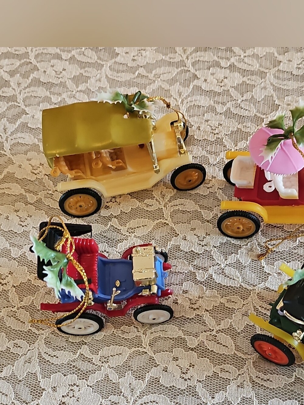Set of four vintage KMC plastic antique car Christmas ornaments.